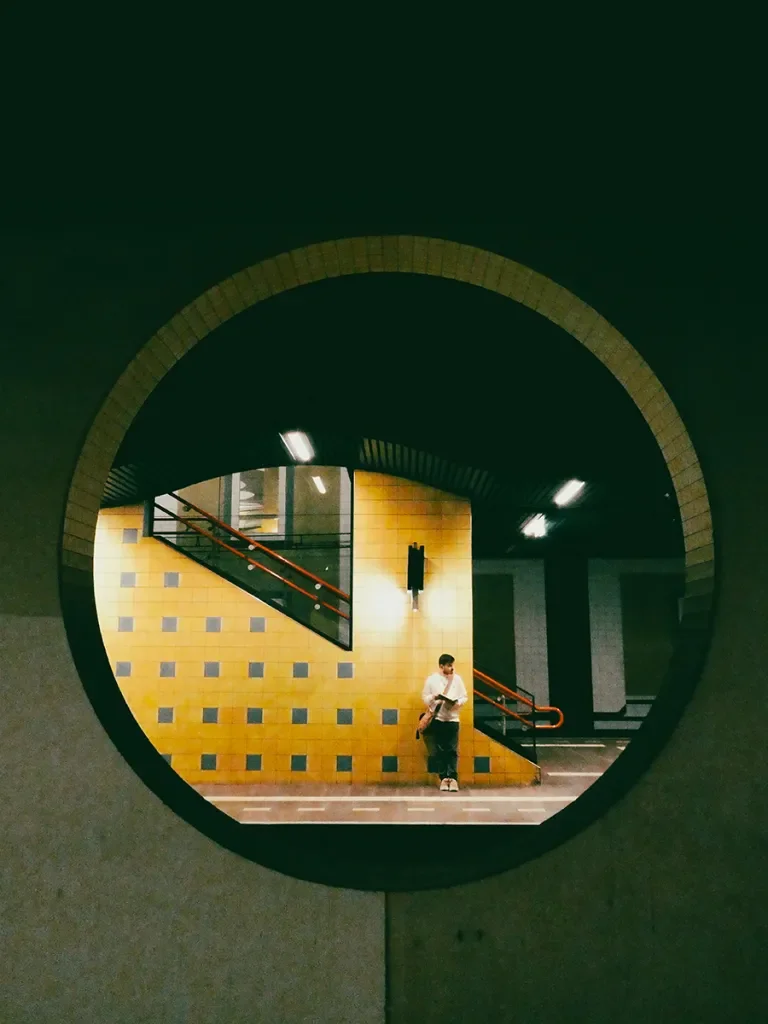 looking through a circle in the wall to a train platform