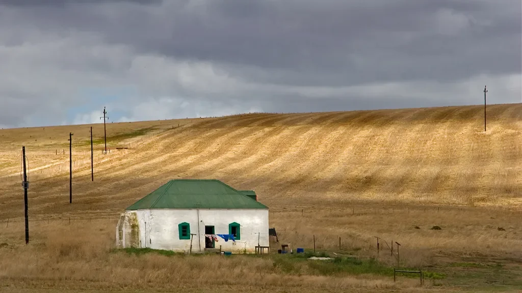 white small house in the middle of the field