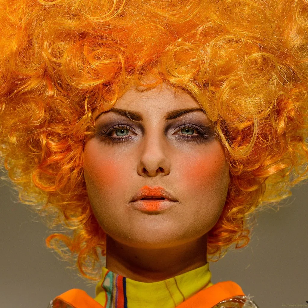 portrait of a model wearing an orange wig and orange make-up