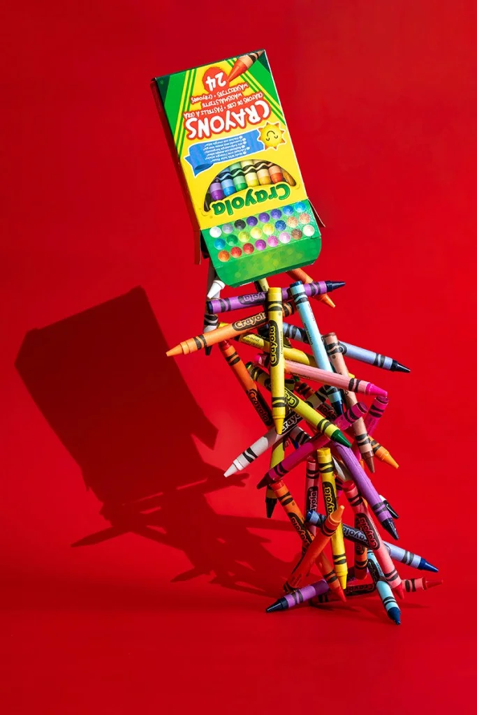 crayons pouring out of packet against red background