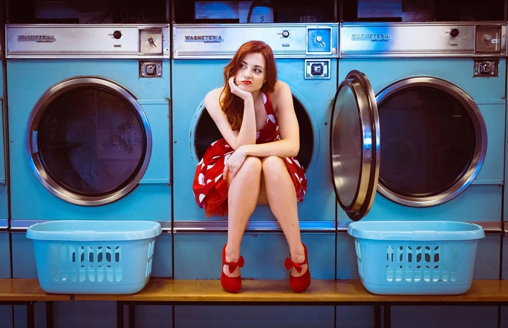 woman wearing red sat in a blue washing machine