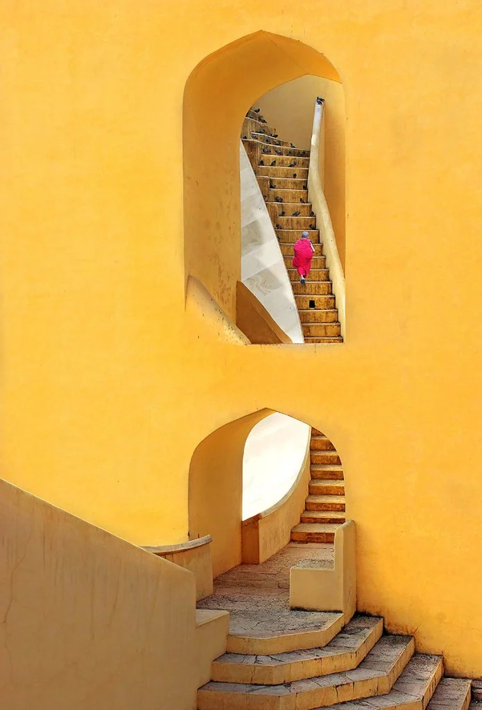 yellow architecture with person in red walking in the middle