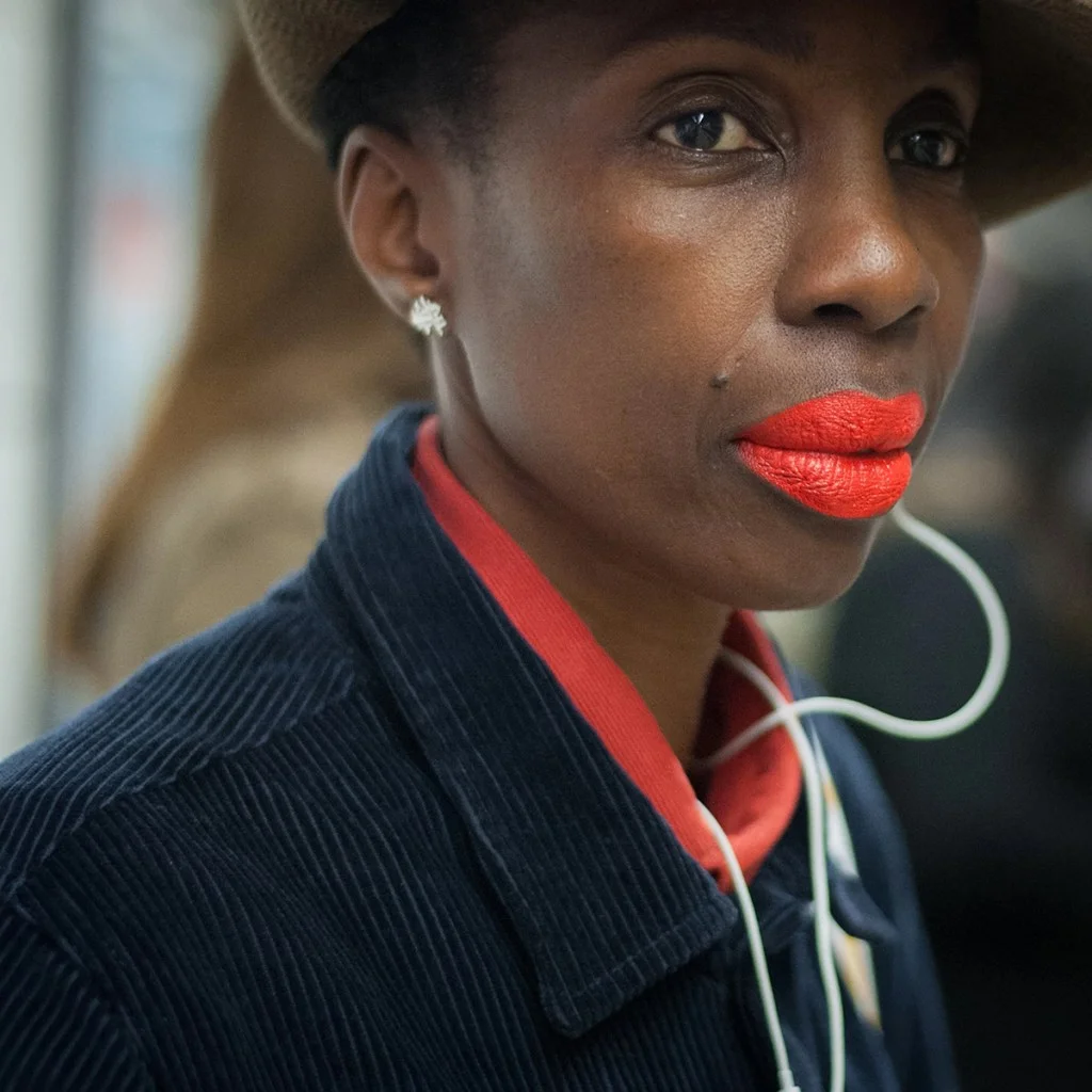 close-up portrait of a woman wearing a red collared shirt and bright red lipstick