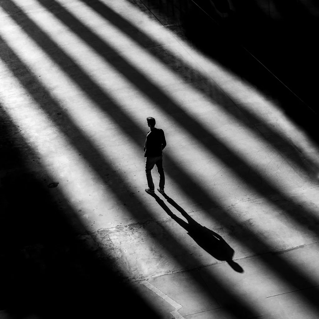 person stood in a light gap between shadows