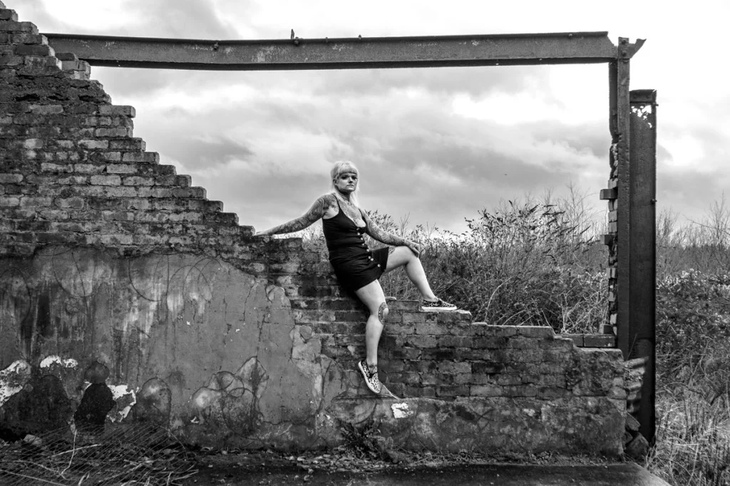 portrait of a woman in the frame of a derelict building