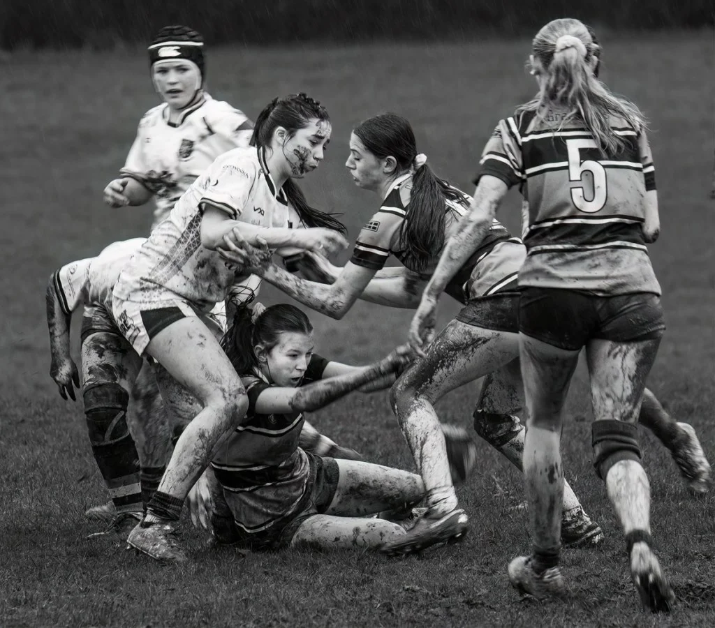 black and white photo of women playing rugby