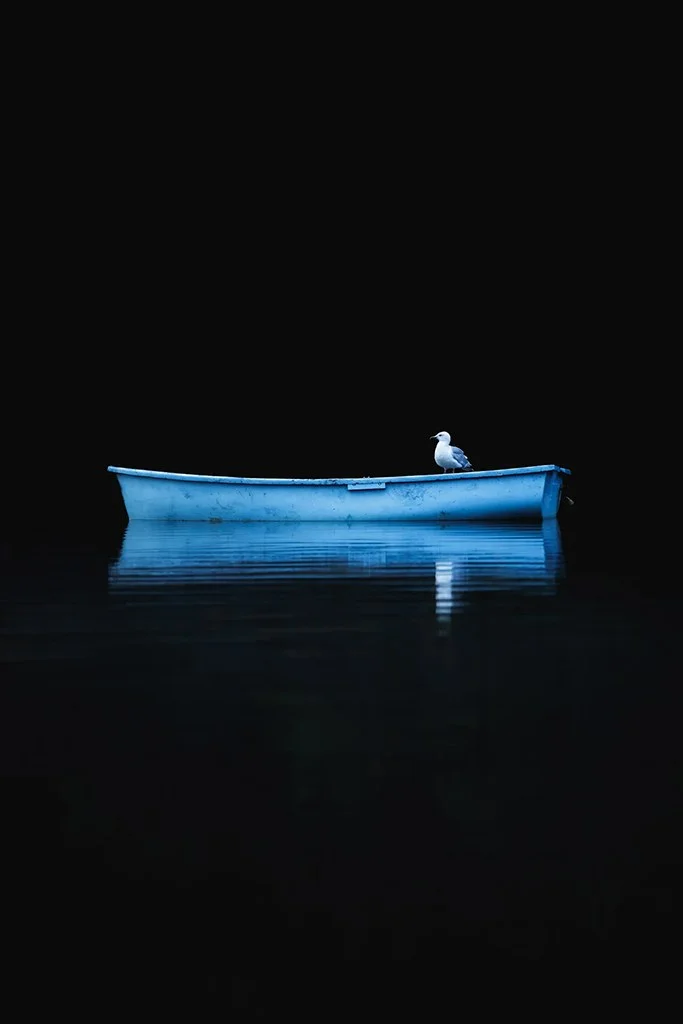 bright blue rowing boat against black background