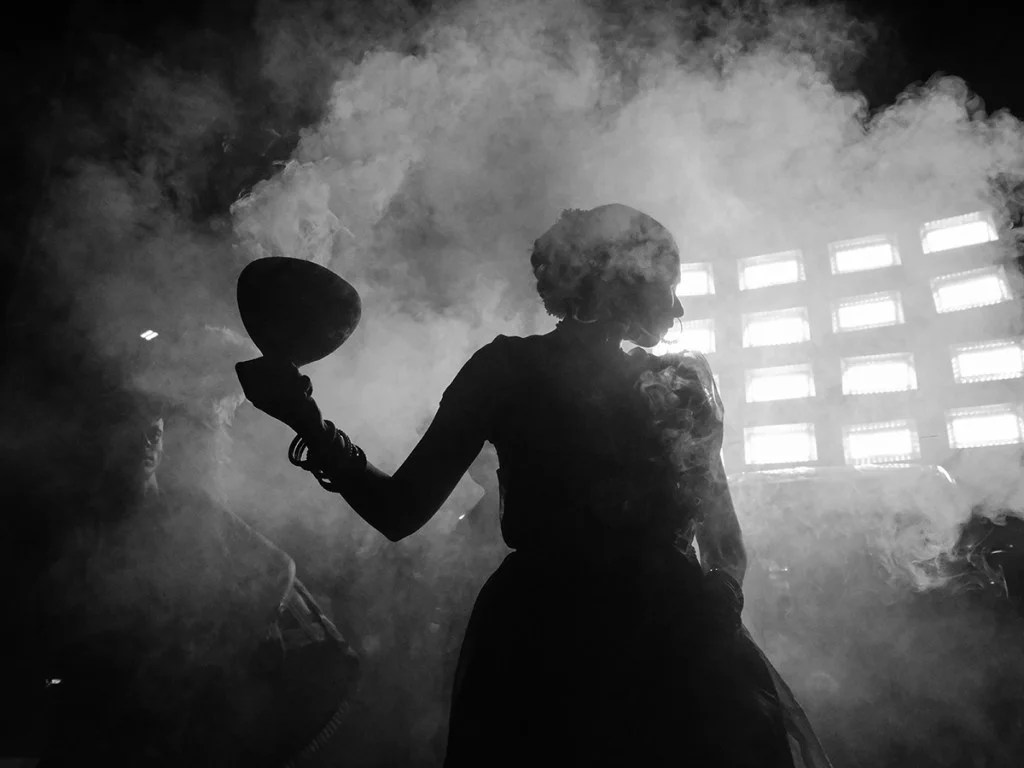 Silhouette of a woman surrounded by smoke holding a bowl