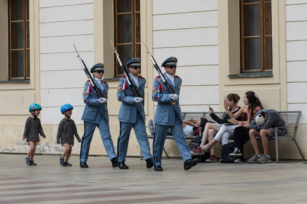 Two children mimicking guards they are walking behind