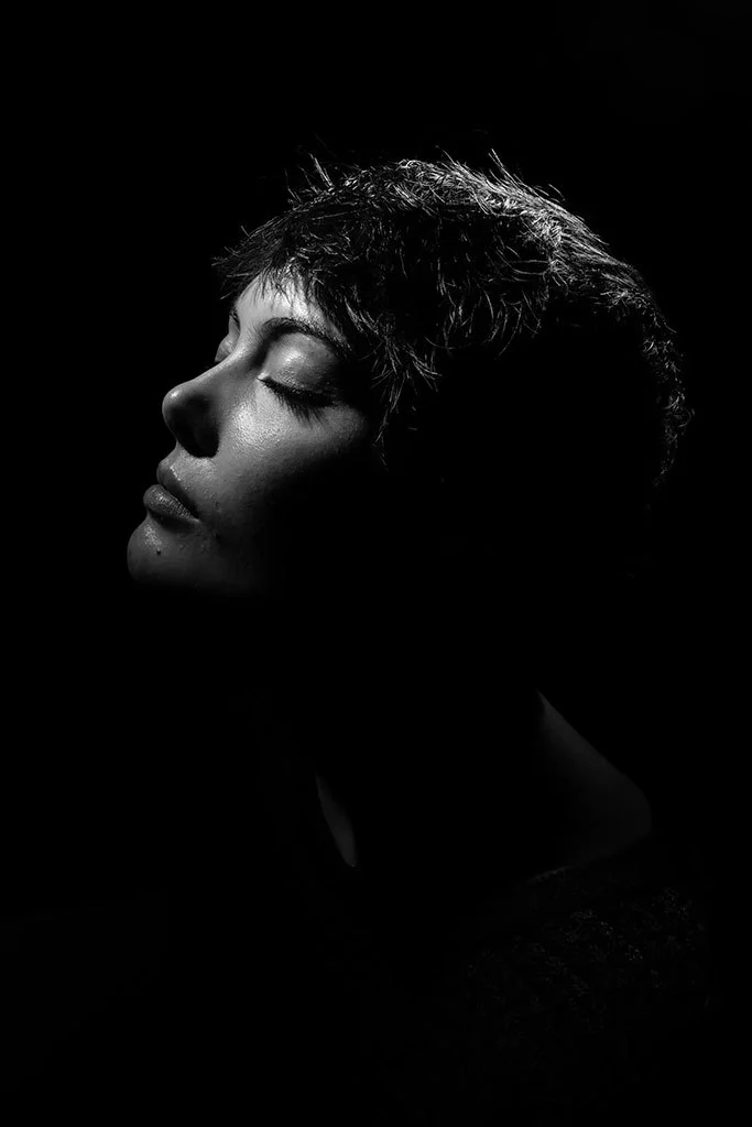 Black and white portrait of a woman in shadows