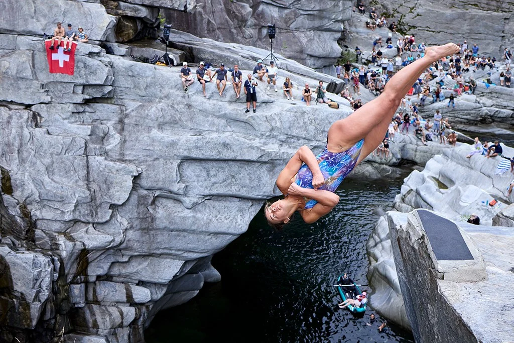 person diving off a cliff