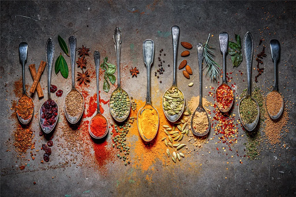 Flatlay of spoons holding different herbs and spices