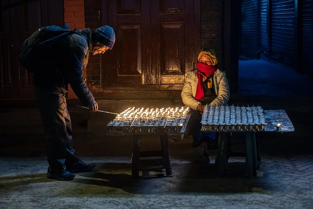Person lighting candles at night
