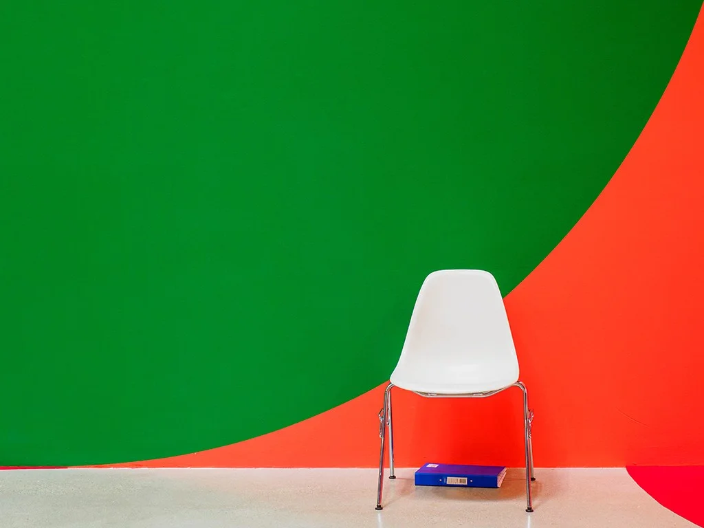 white chair against green and red wall