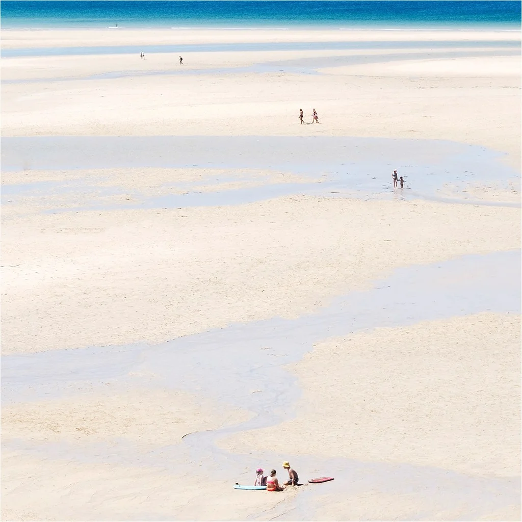 minimal beach sandy landscape with a few groups of people dotted around