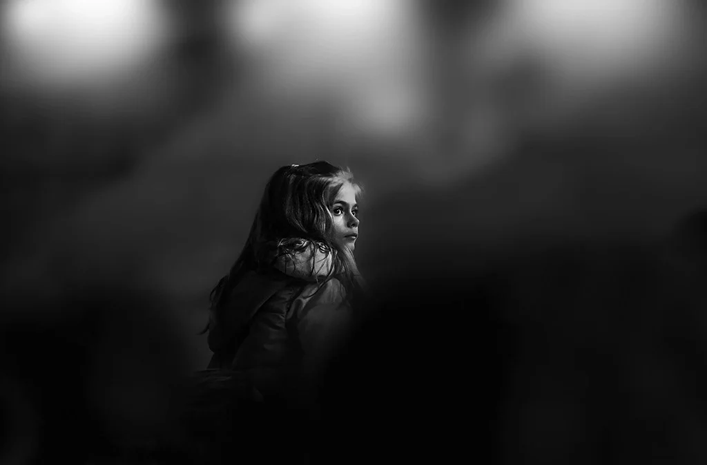 Young girl at a concert appearing contemplative