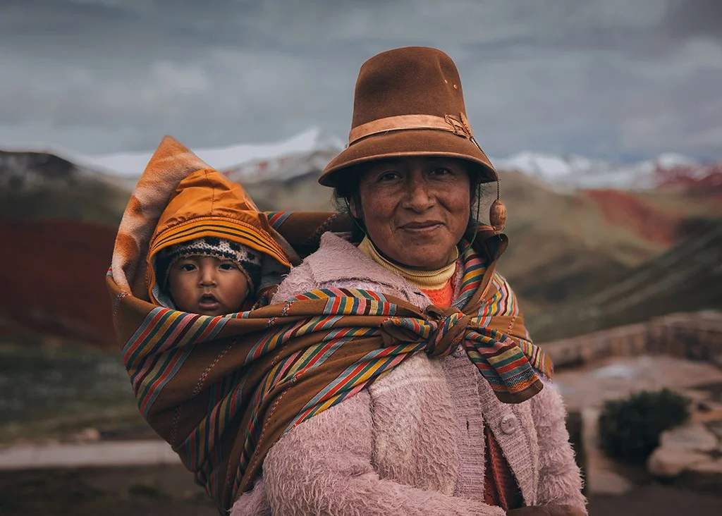 portrait of a Peruvian woman with a young child on her back