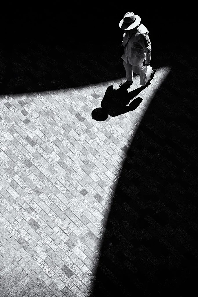Person walking through light and shadows