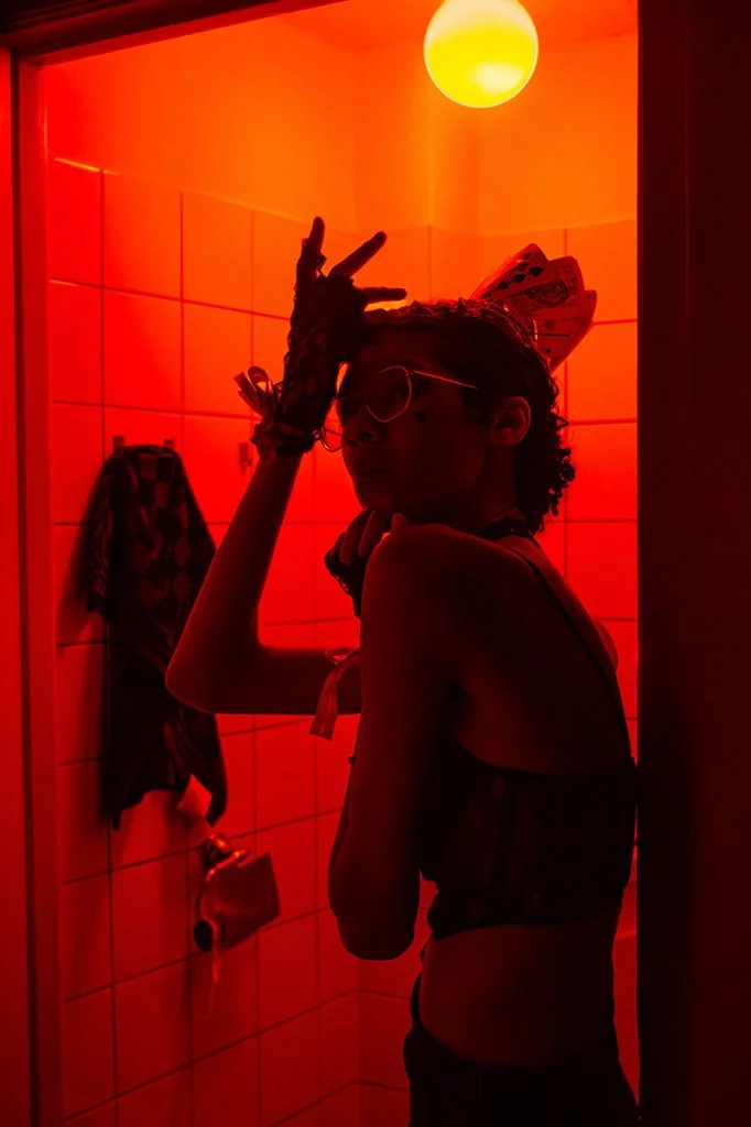 model posed in tiled room with bright red light dusk to dawn example