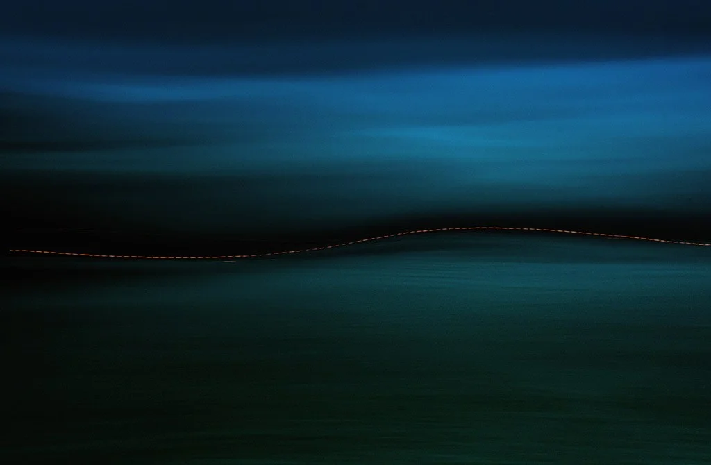 dashed orange light flickering through the middle of the frame of dark low light creative scene dusk to dawn