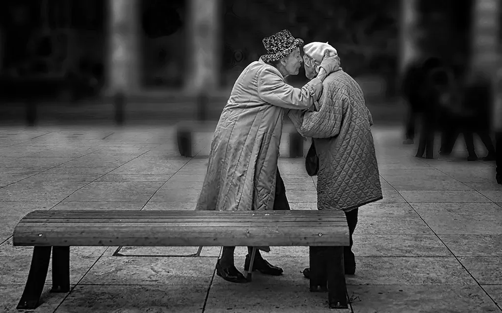 intimate moment of elderly people whispering in each other’s ear